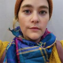 Headshot of Amanda, wearing a yellow sweater and a colorful scarf.